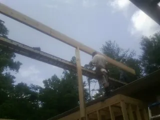 Carpenter setting a ridge beam over a new addition frame — Ice Dam Removal by Roofing Brothers in Trout Run